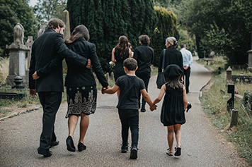 Grieving family walking through cemetry