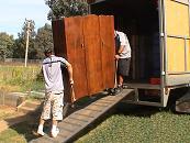 2 men loading truck with straps