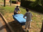 2 men wrapping glass table