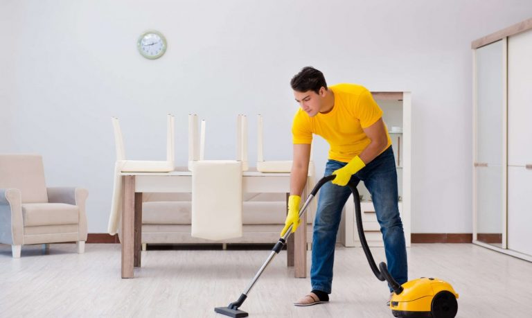 man cleaning house with vaccum 1210x723 1 768x459