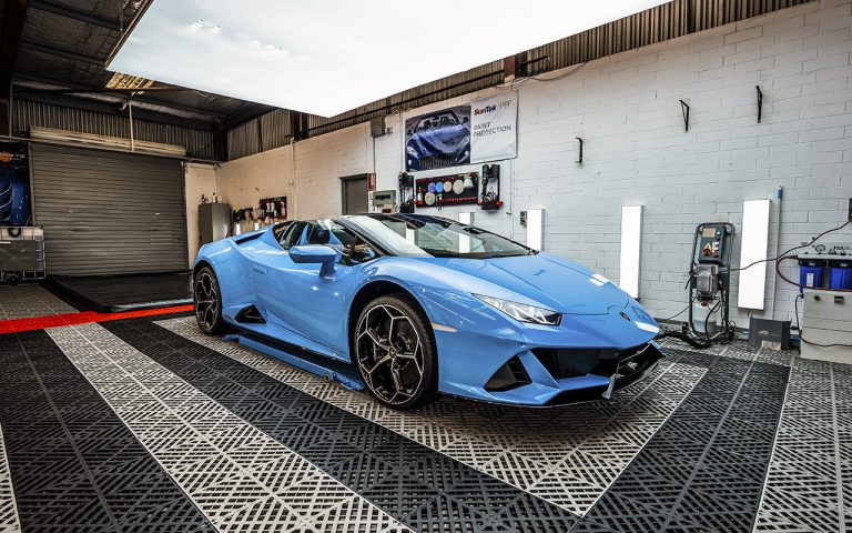 craftsmen automotive professionals paint protection services on blue lamborghini in side auto shop 768x480