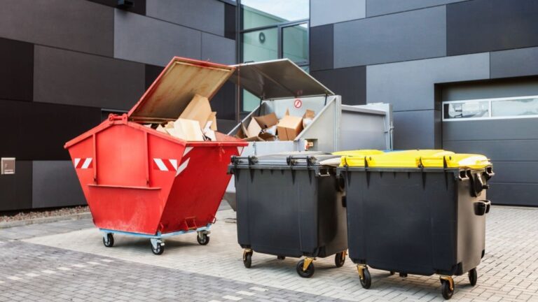 Red dumpster recycle waste and garbage bins near new office building 768x432